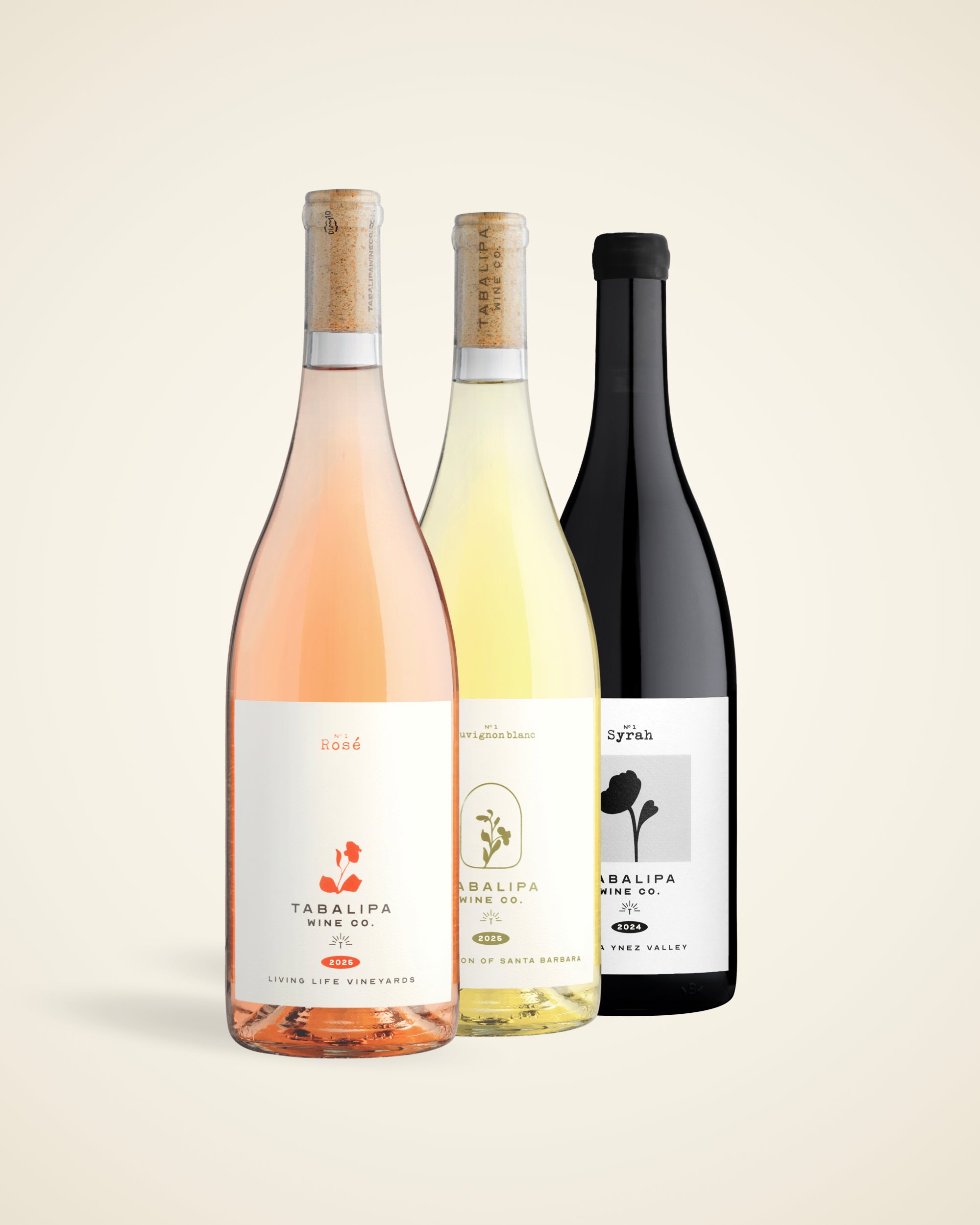 Three wine bottles from Talipa Vine Co. arranged together on a light beige background: a rosé wine bottle with a pinkish-rose liquid, a pale yellow wine bottle, and a dark red wine bottle with a black label.