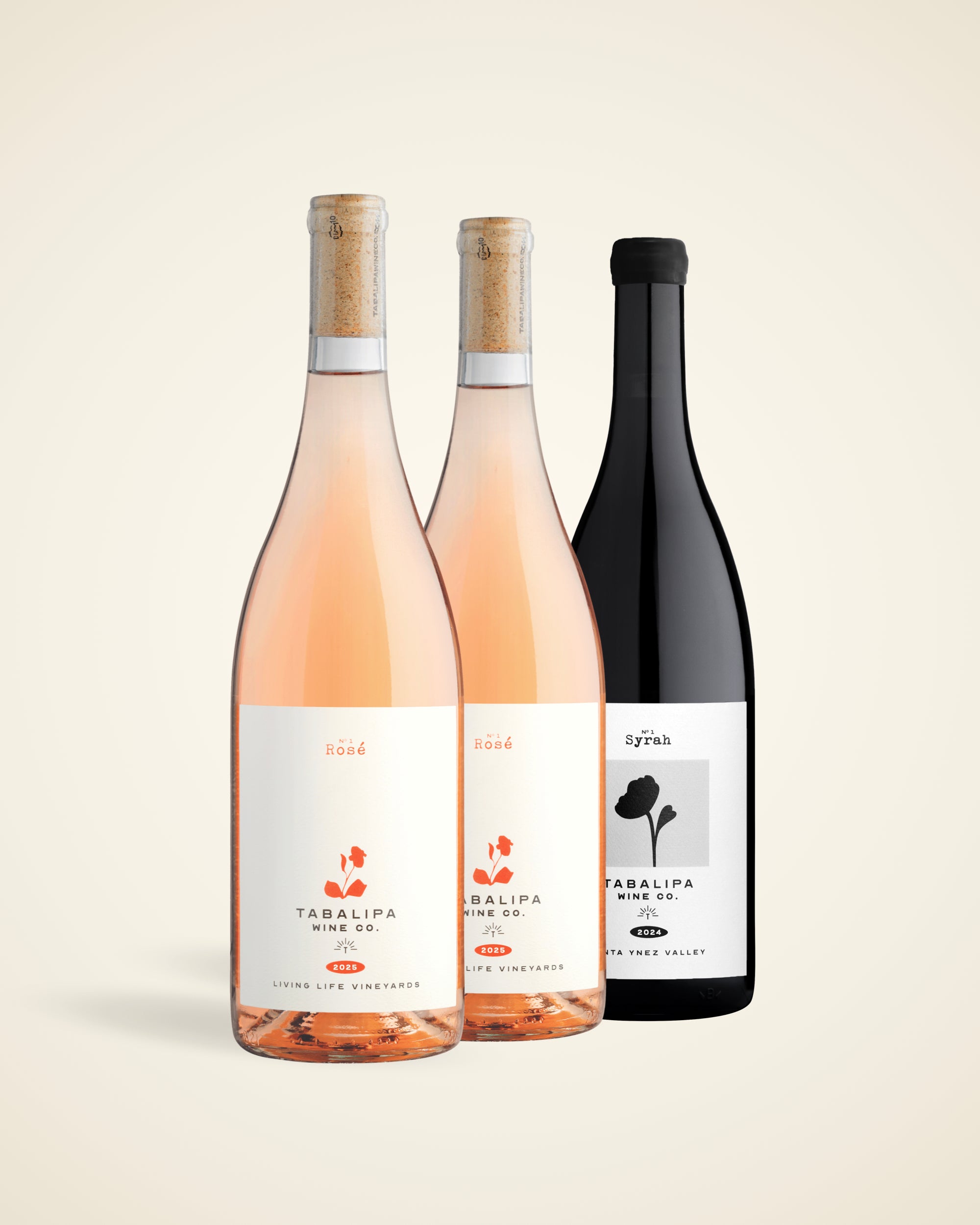 Three wine bottles from Talalipa Winery arranged against a light beige background: two pale pink rosé wine bottles with cork stoppers and a single dark black wine bottle with a black cap.