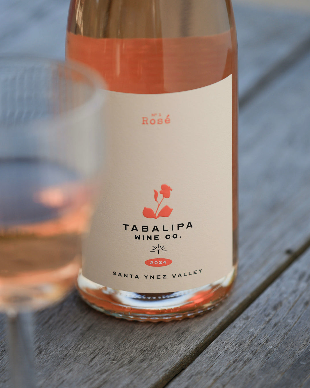 Glass of Tabalipa Nº1 Rosé wine next to the full bottle of No. 1 Rosé.